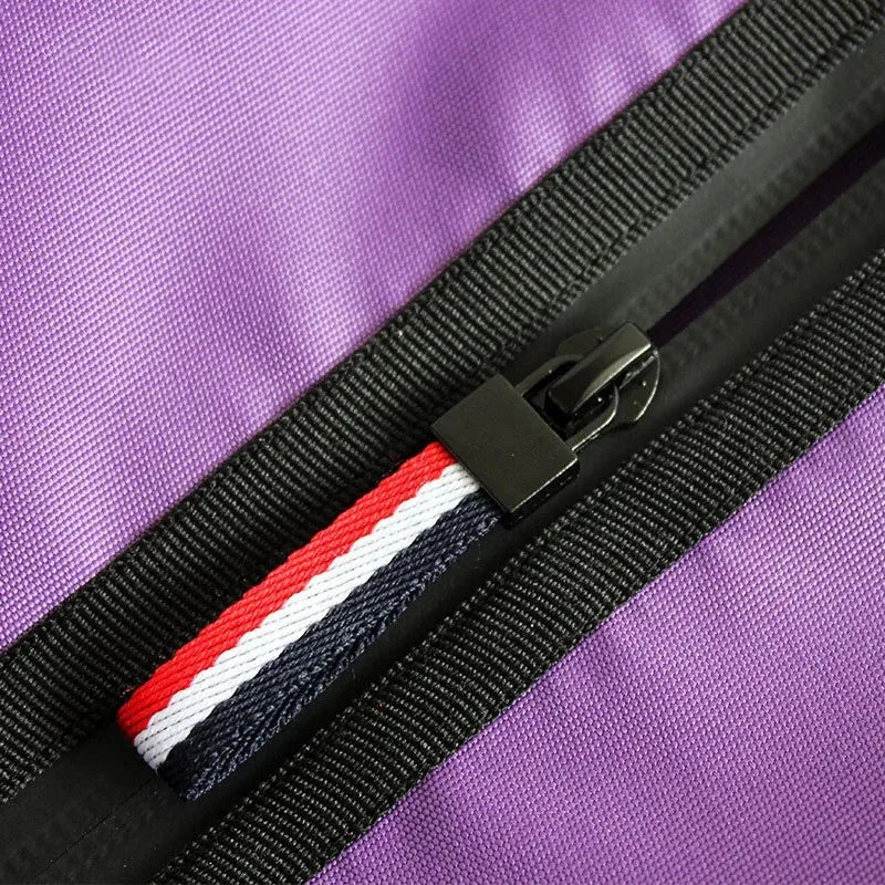 Close-up of a purple bag with a black zipper featuring a red, white, and blue pull tab.