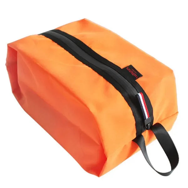 Orange bag with black zipper and strap on a white background